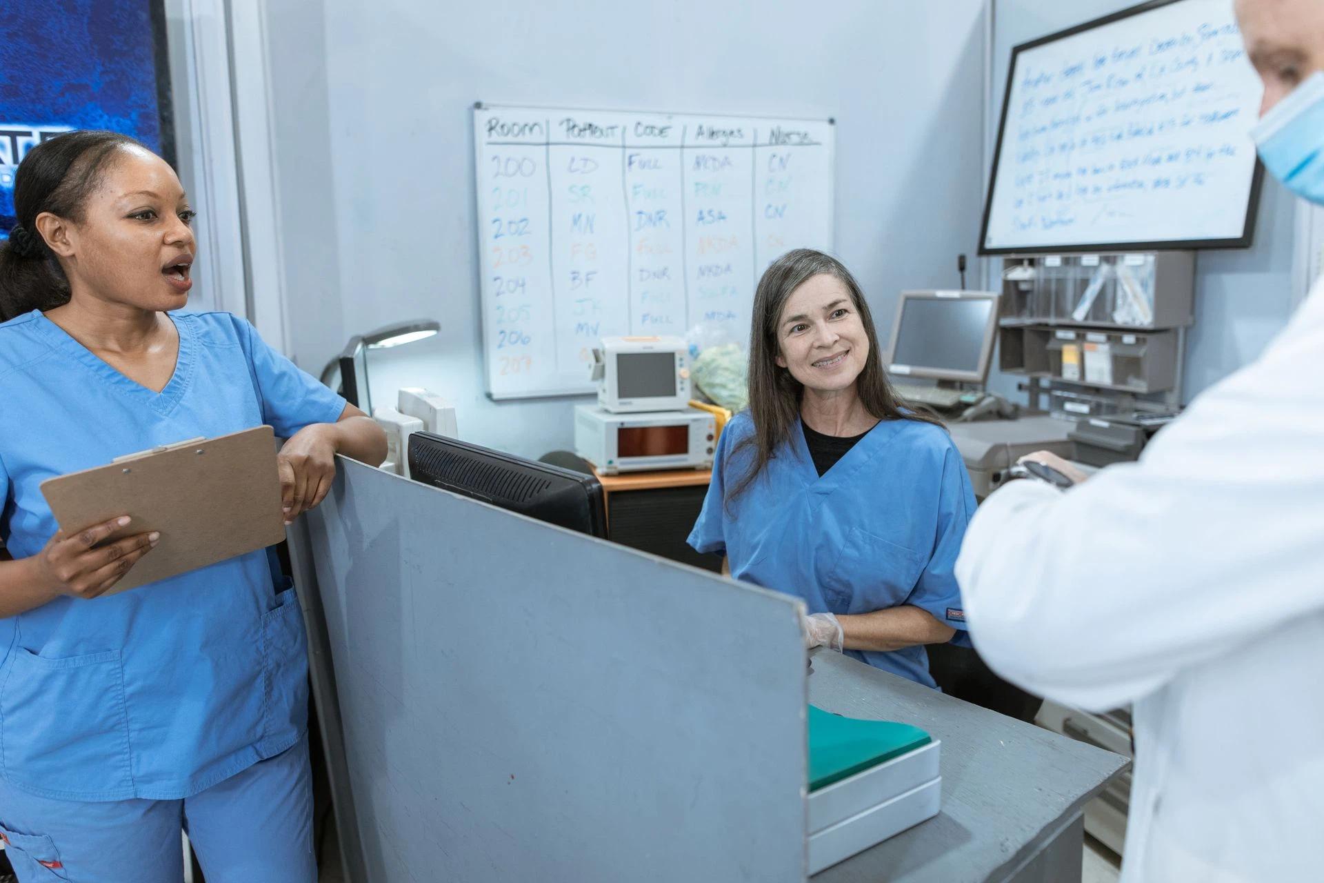Group of nurses and a doctor collaborating at a hospital reception area with medical equipment in view