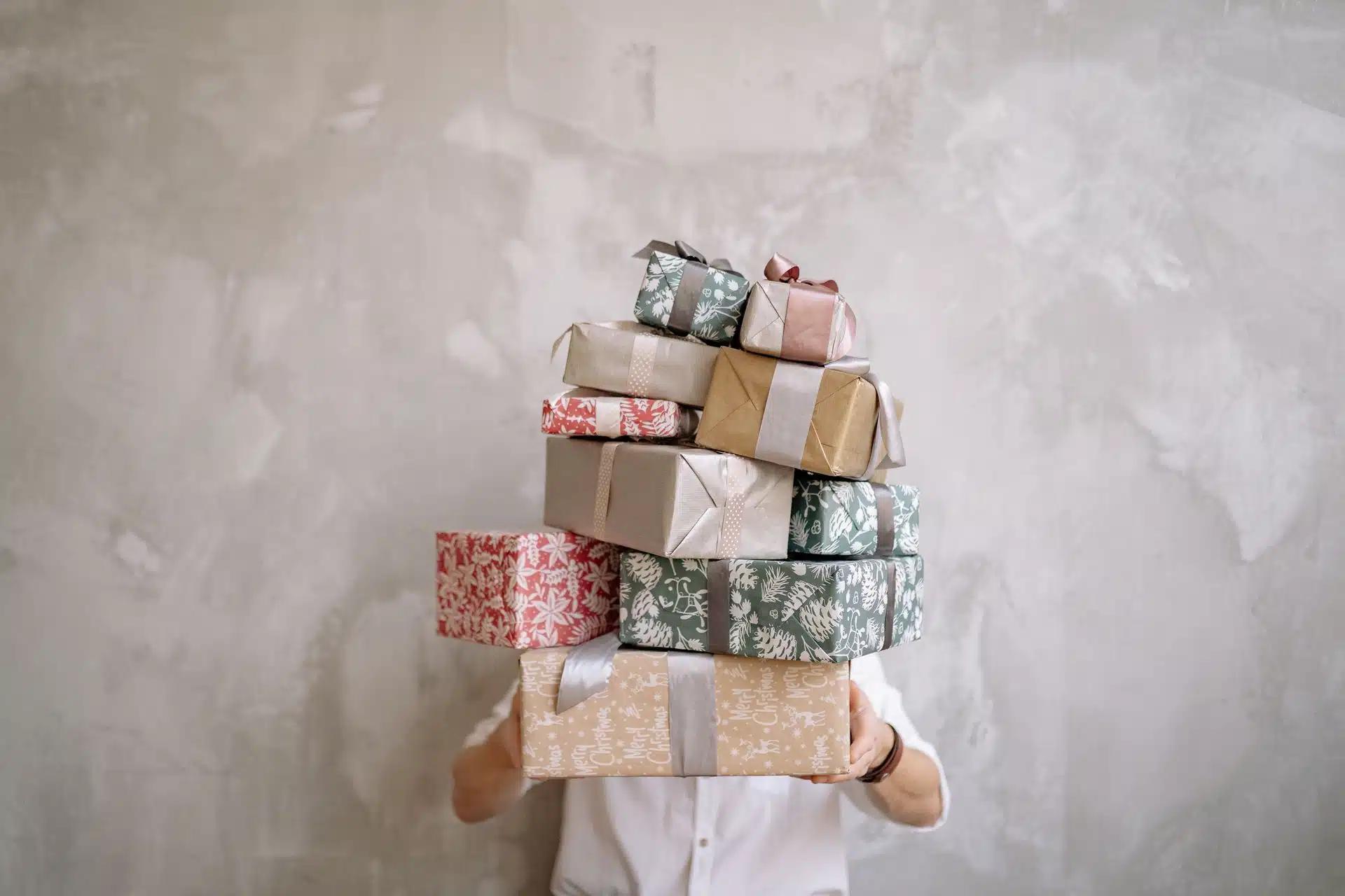 Person holding a stack of gift boxes