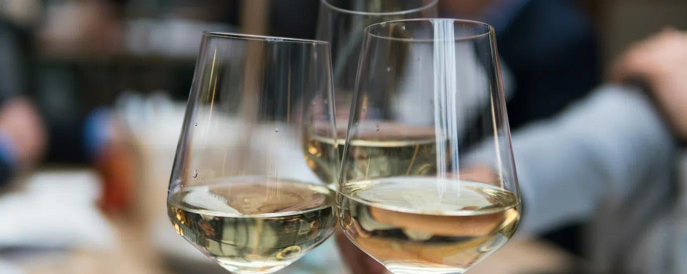 Three toasting white wine glasses