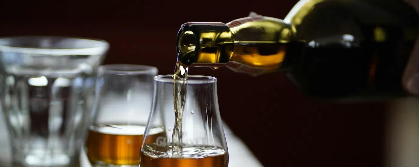 Whiskey pouring into a tasting glass