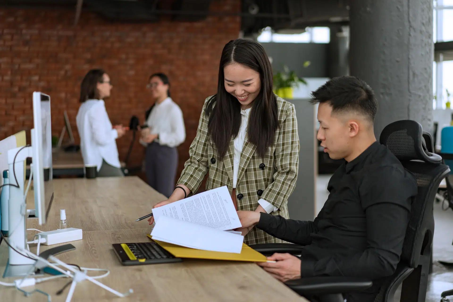 Professionals engaged in teamwork at a modern office desk reviewing documents
