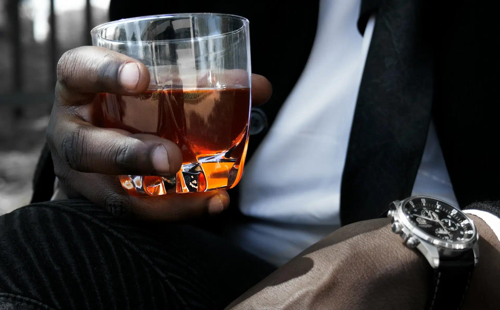 A man holding a glass of whiskey