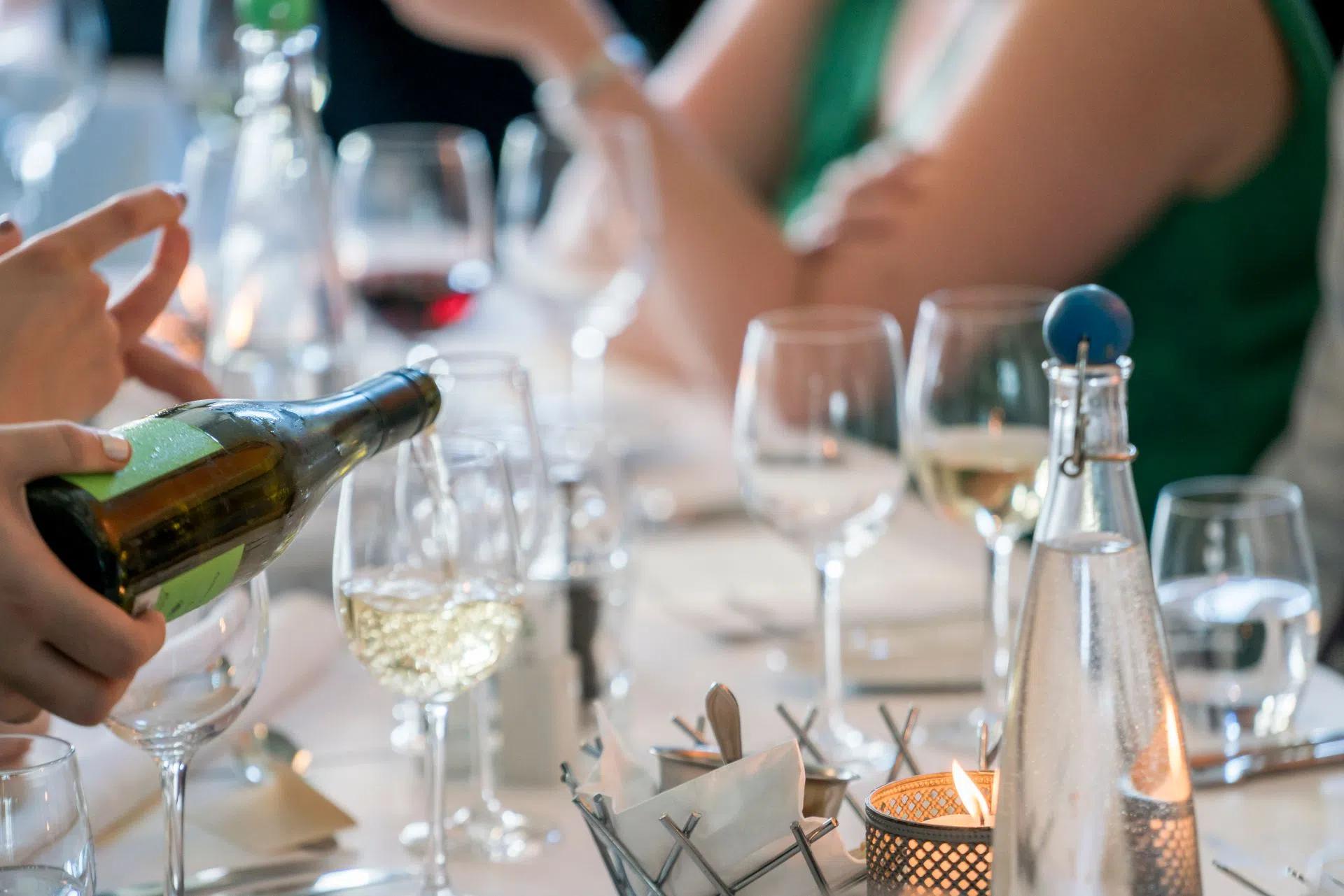 A busy table with wine glasses during lunch