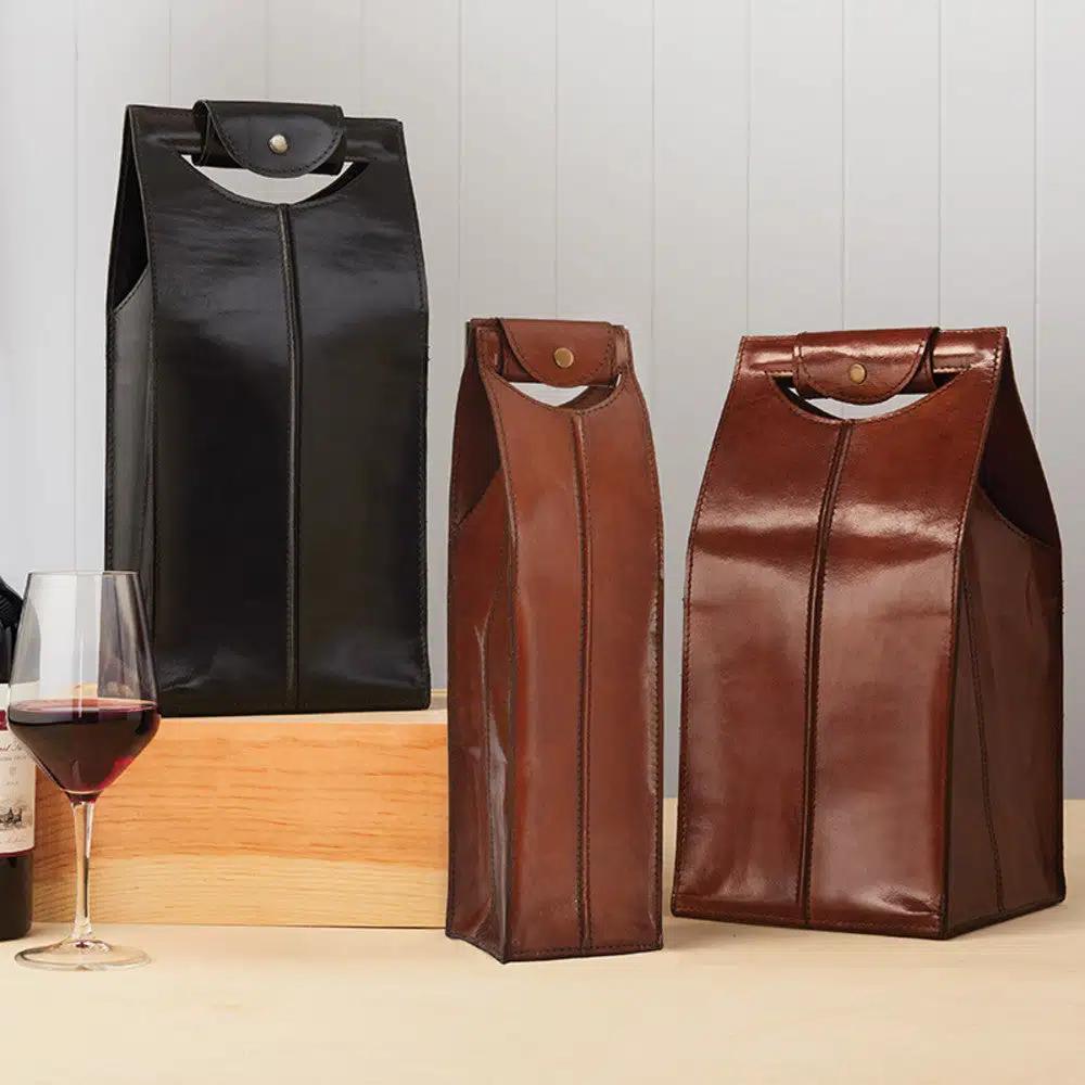 A selection of leather wine totes displayed on a table