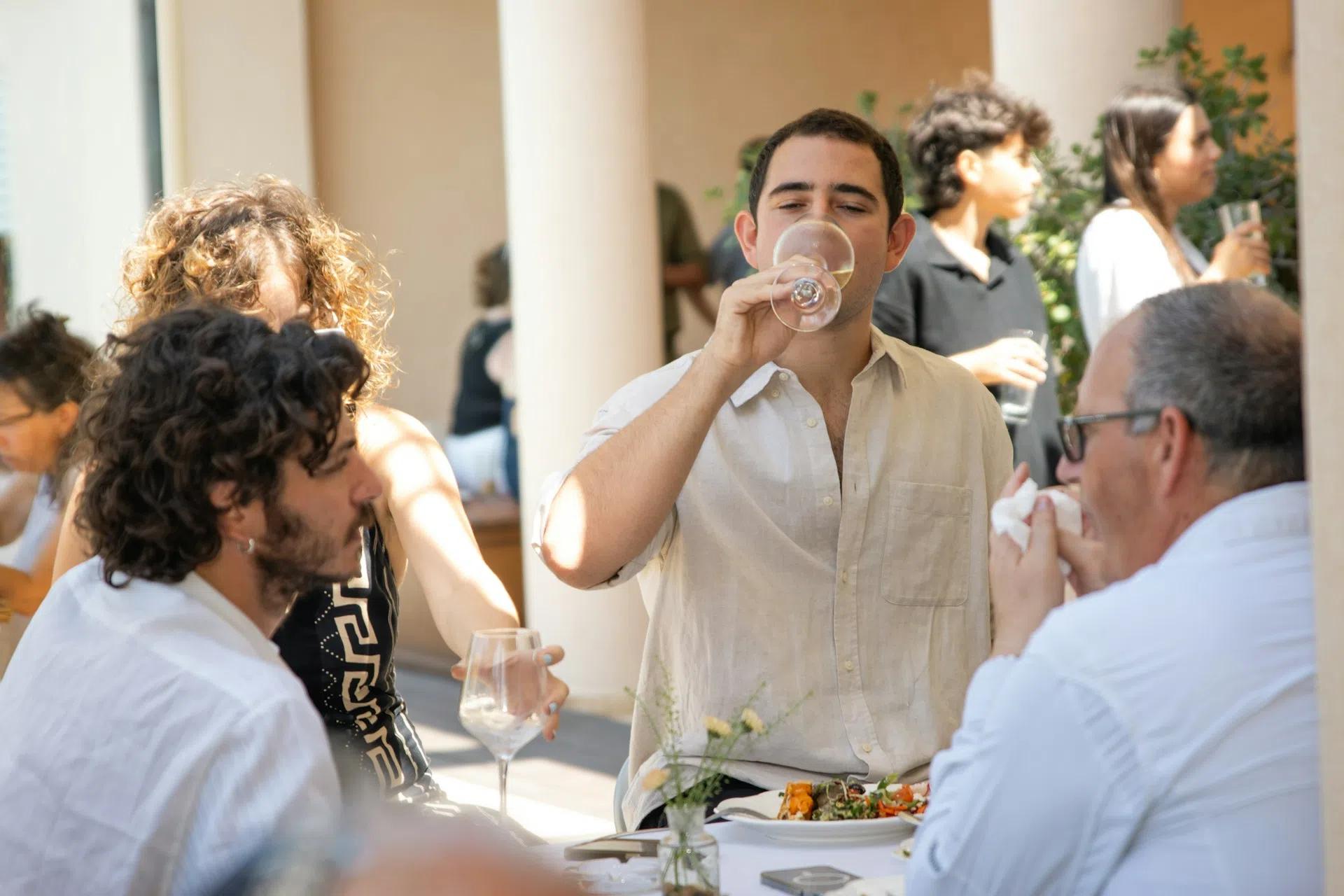 A man drinking wine at an outdoor event