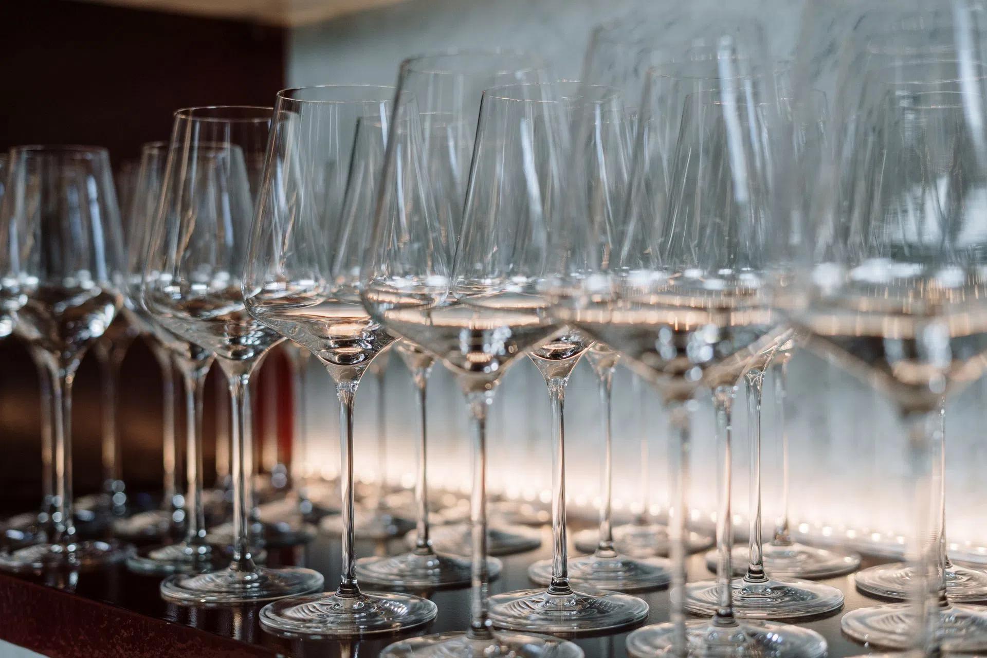Row of crystal wine glasses neatly arranged on a shelf, highlighting elegance and luxury