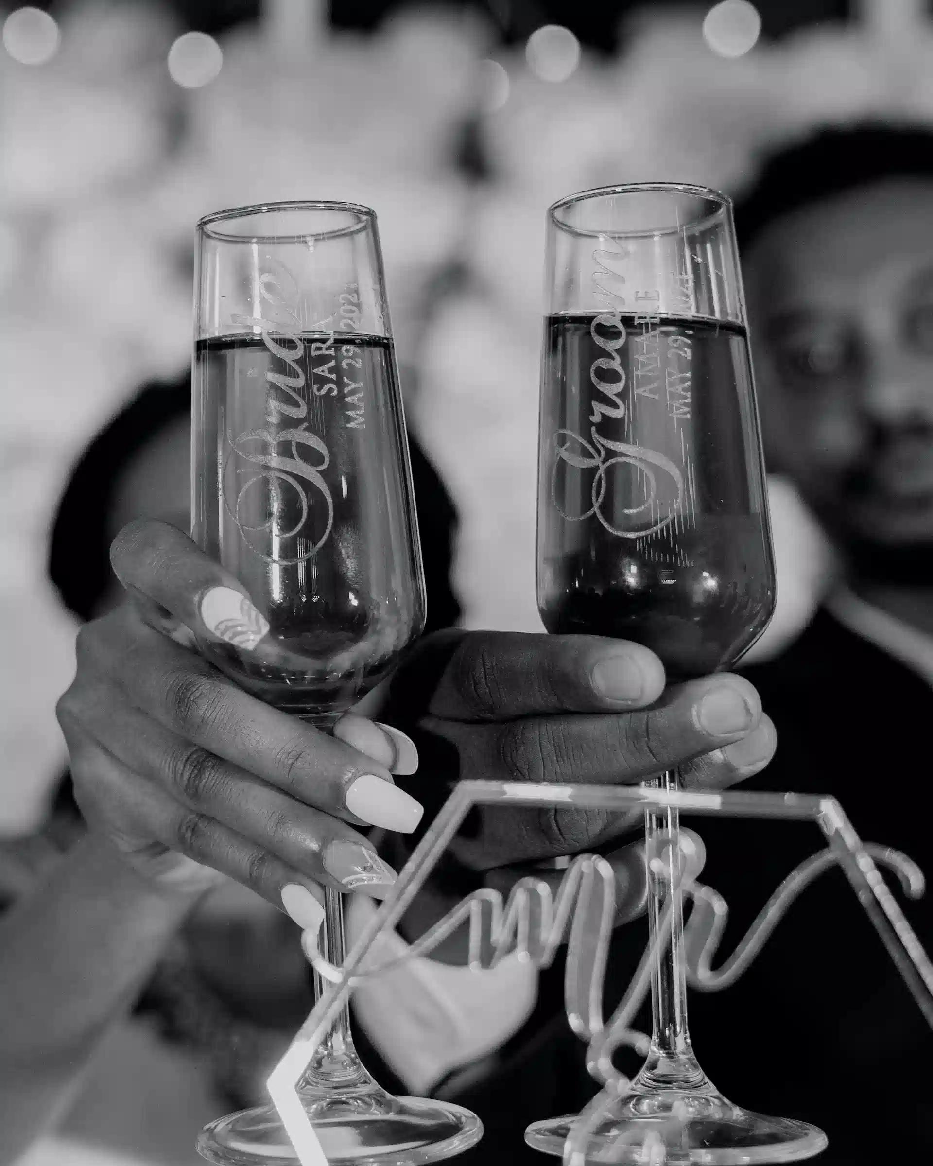 A pair of engraved bride and groom champagne flutes