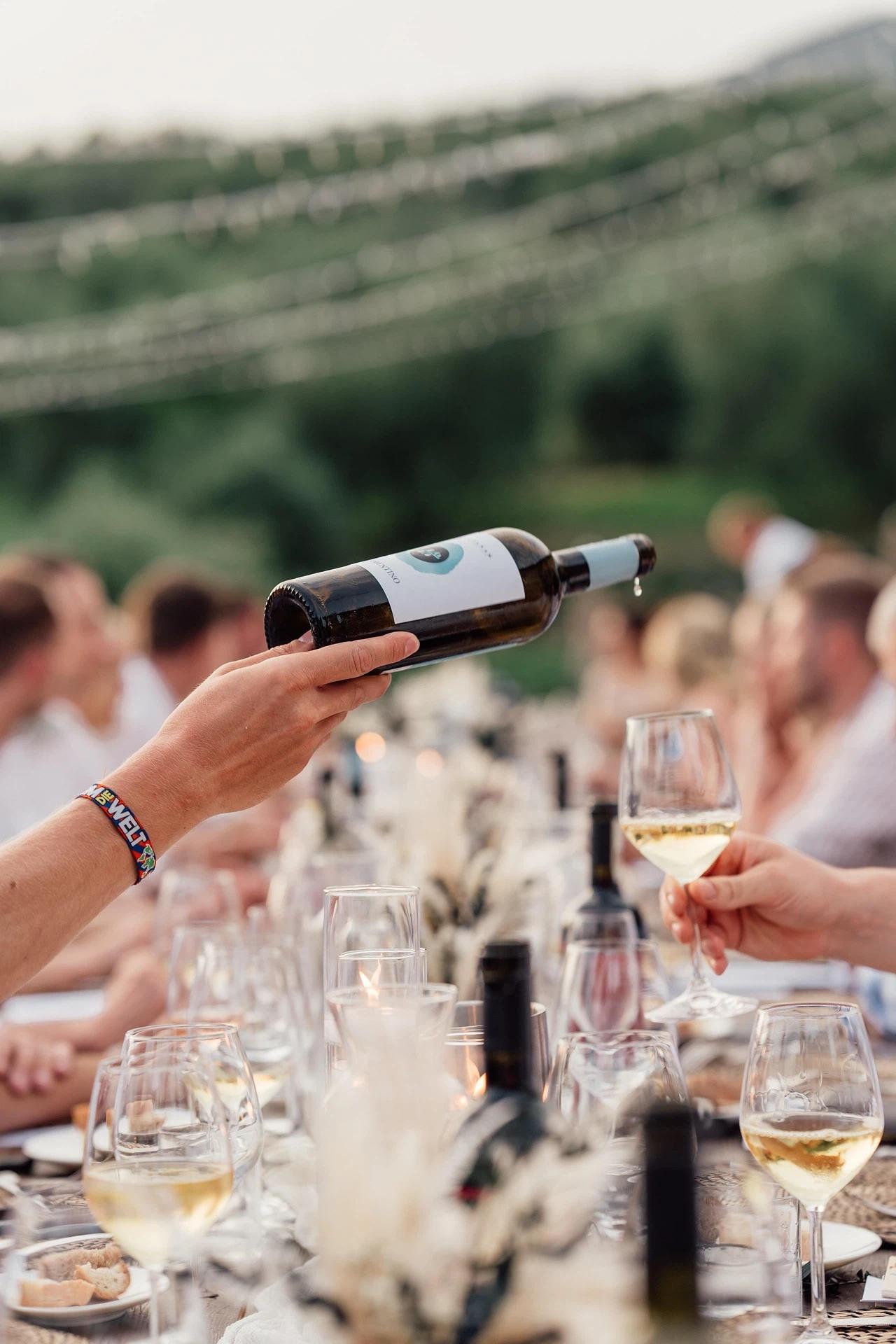 Pouring white wine into a wine glass at an event