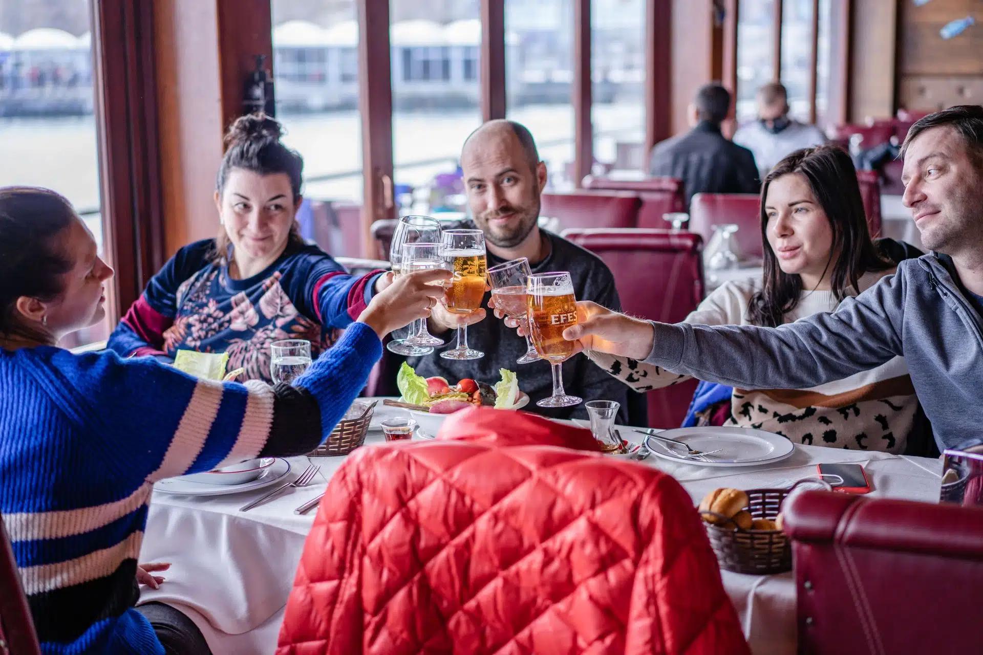 A group of friends sharing a meal and toasting at a restaurant