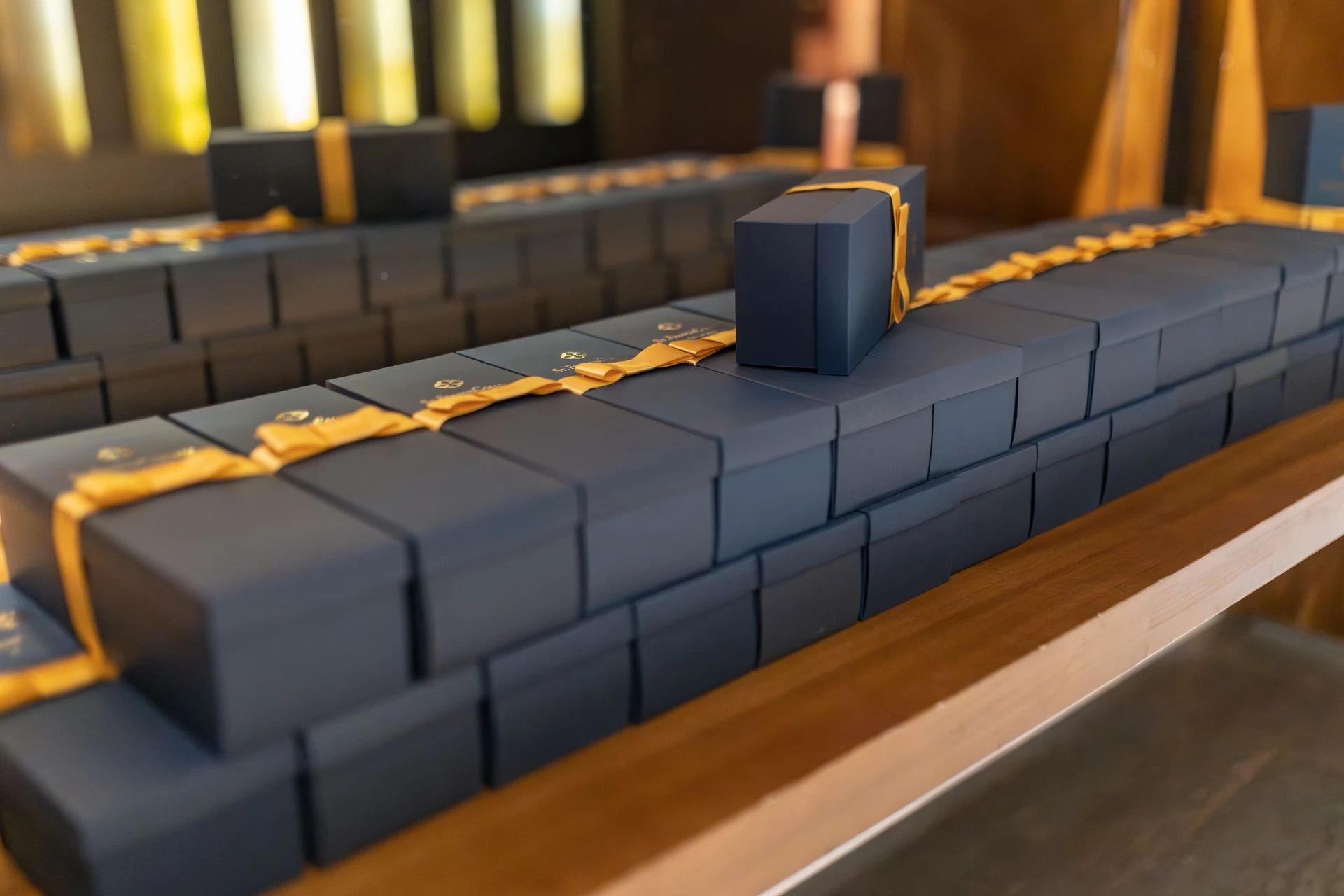 Elegant black gift boxes adorned with gold ribbons, perfect for luxury events or holiday celebrations