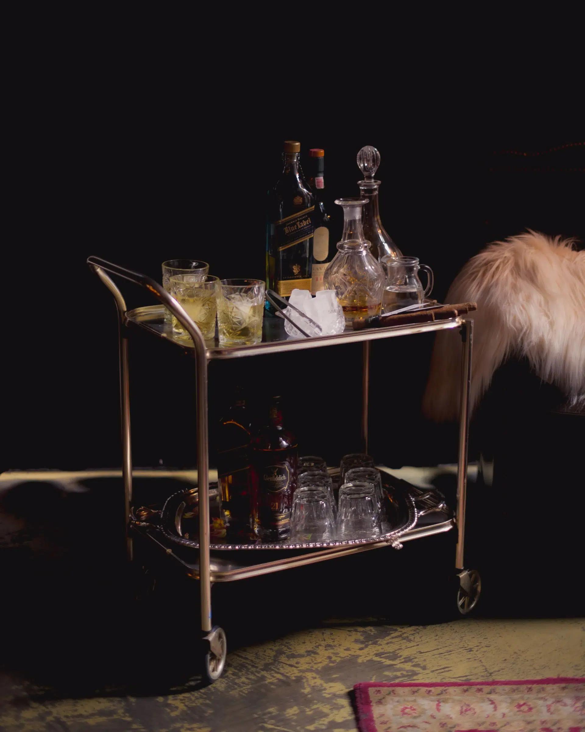 Elegant bar cart showcasing spirits and glassware in a luxurious setting