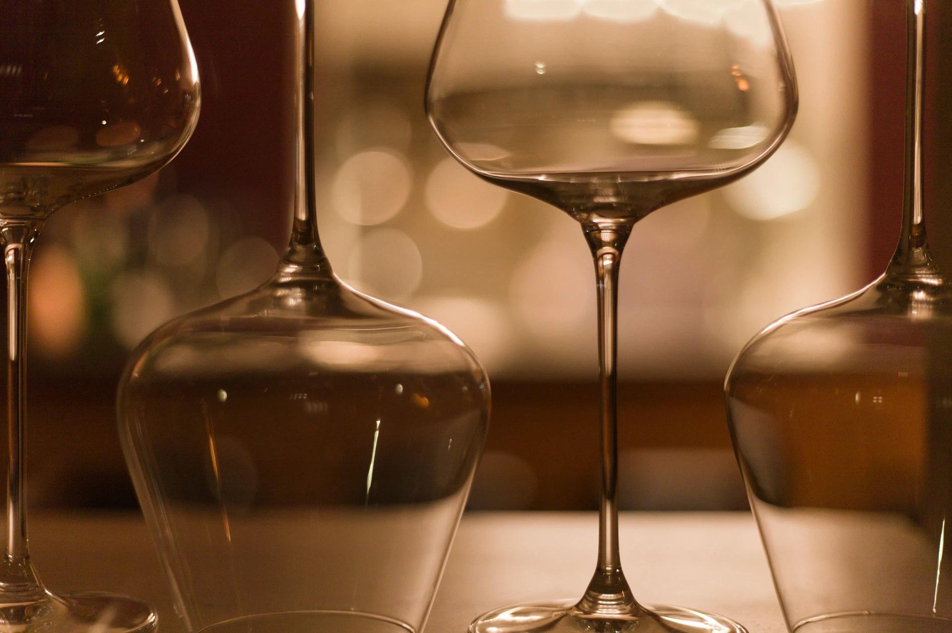 A closeup shot of wine glasses in a warm tone