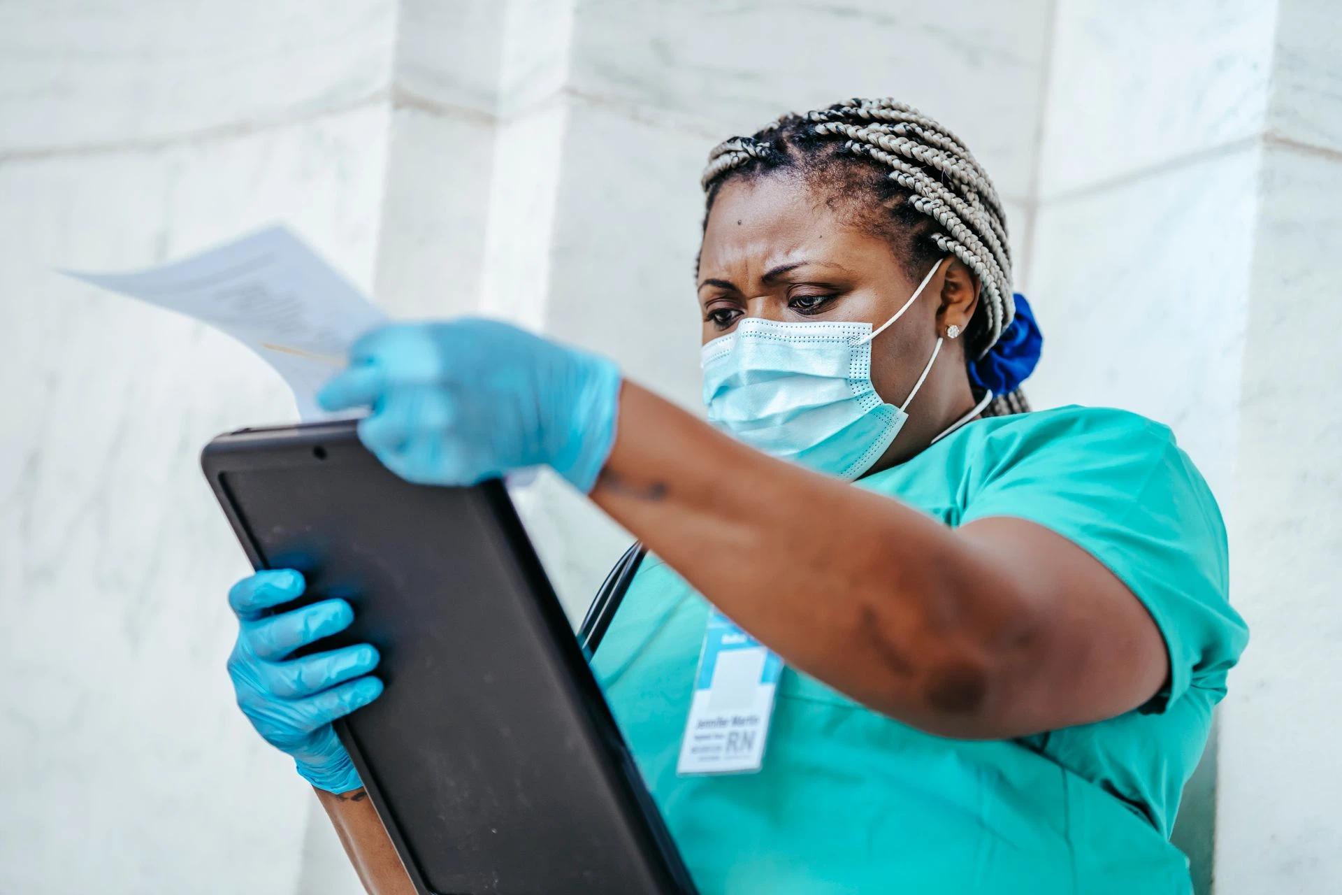 Nurse in hospital uniform analyzing documents with focus and care