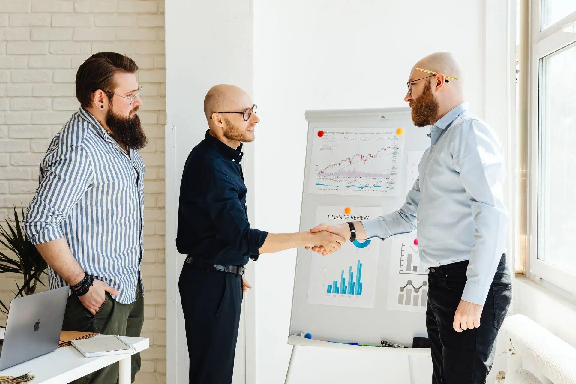 Three business colleagues engage in a productive meeting, exchanging ideas with data charts