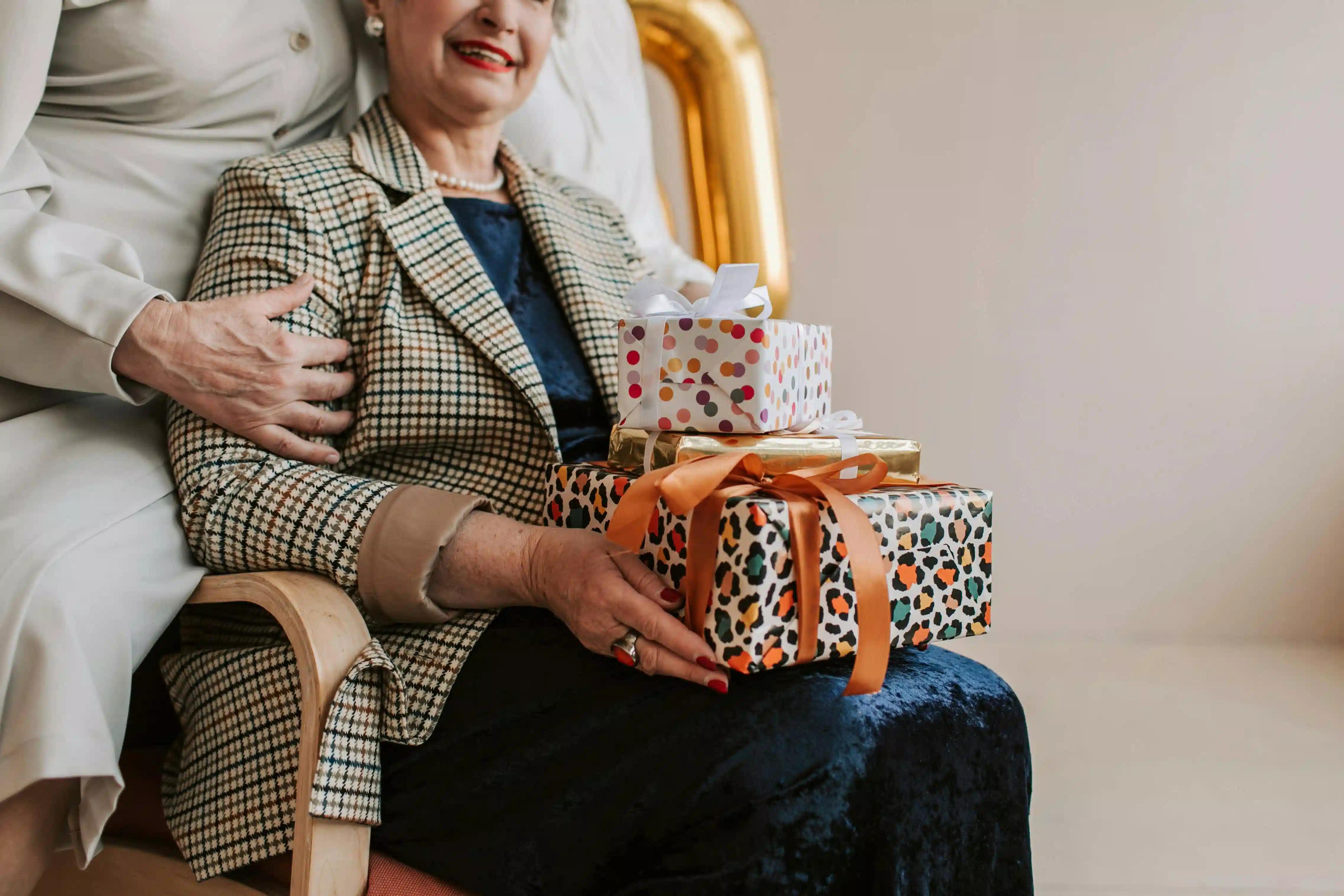 An elderly woman holding gifts