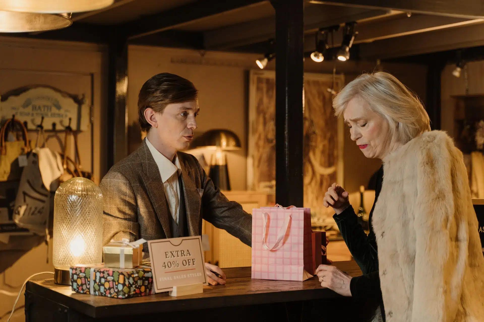 Elegant shoppers engage in a conversation in a chic boutique, showcasing luxury retail ambiance