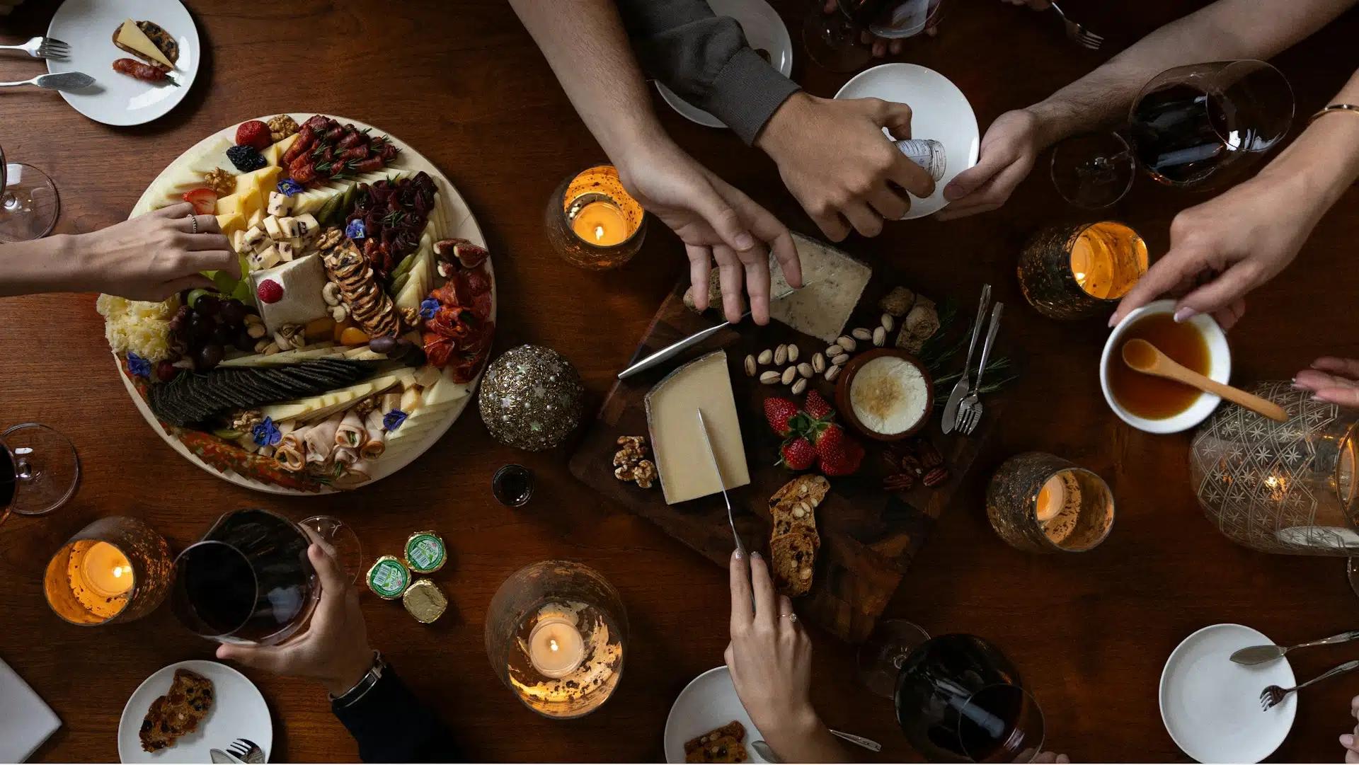 Top shot of a table filled with gourmet food items with people reaching for them