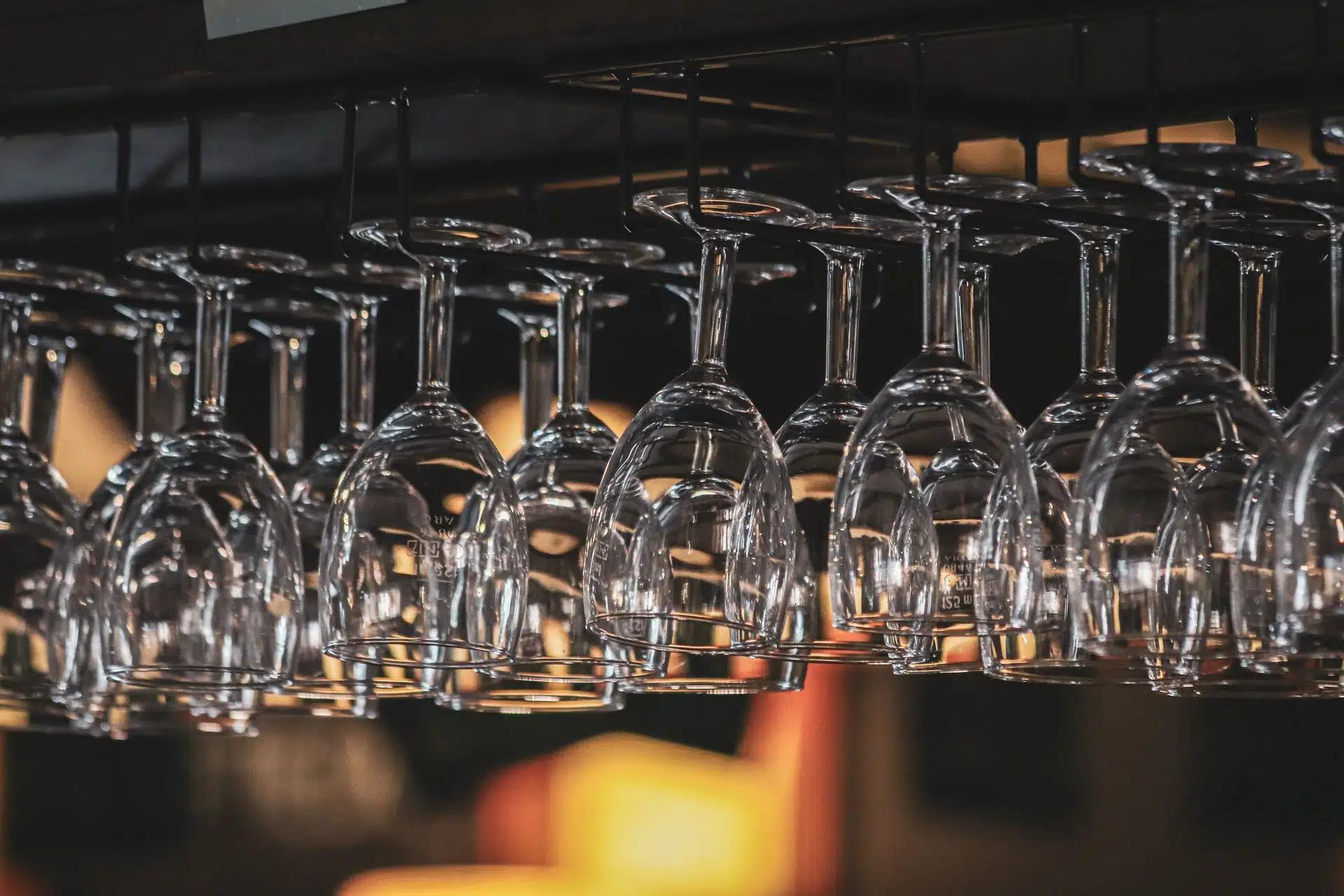 Empty wine glasses on a hanging rack