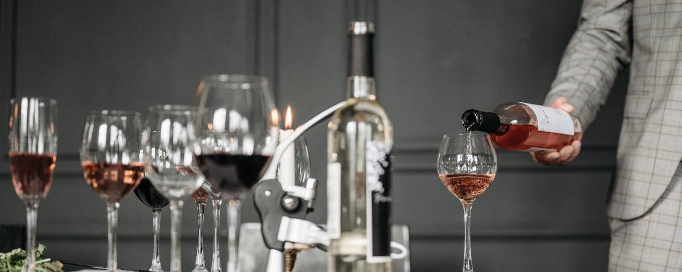 Close-up of a wine tasting session with a sommelier pouring rosé into a glass