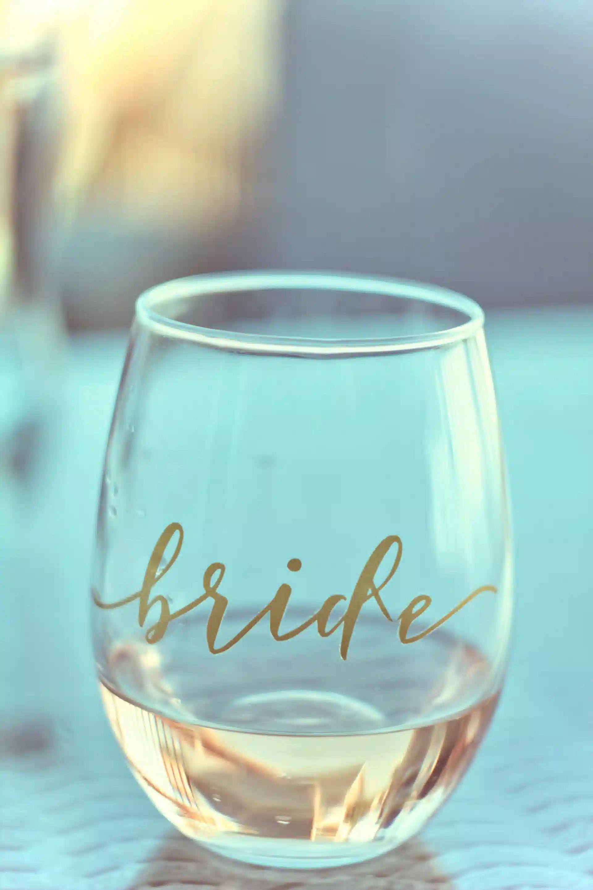 A customized stemless wine glass with the word bride on it