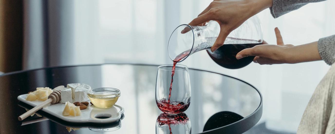 Wine pouring out of a decanter and into a glass