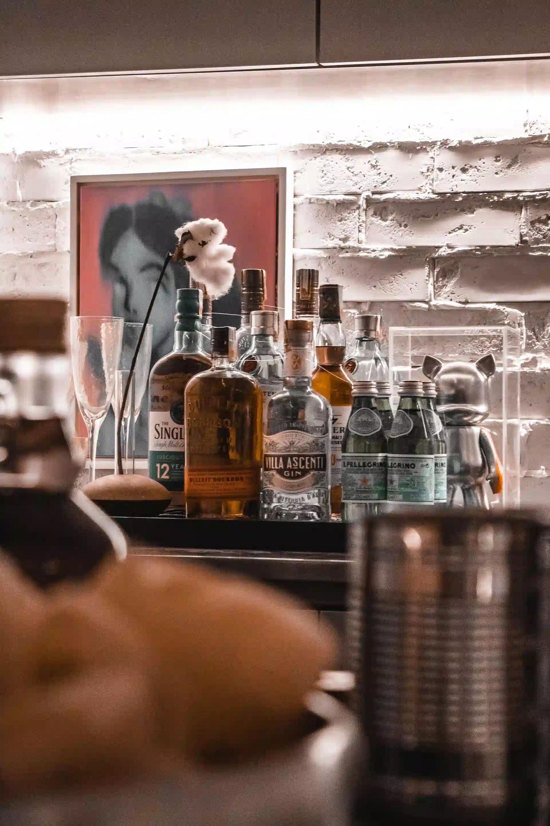 Elegant home bar arrangement featuring various liquor bottles, glasses, and decorative elements