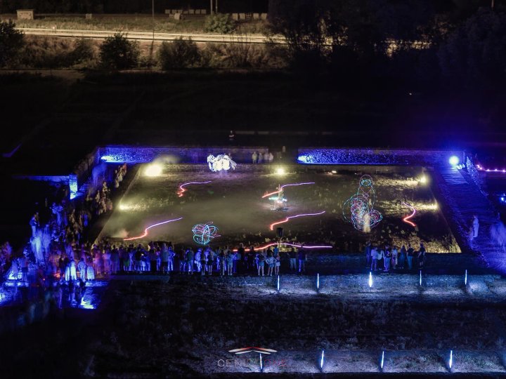 Luchtfoto van het publiek rond de verlichte ruïnes