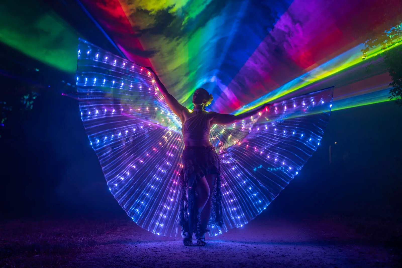 Lichtdanseres met LED-vleugels onder de lasers
