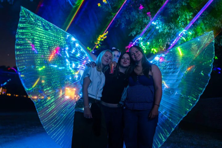 Bezoekers poseren met de lichtdanseres