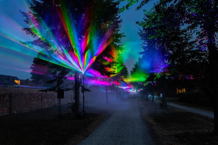 Laserstralen boven het wandelpad tussen de bomen