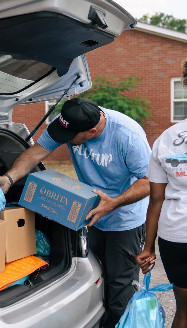 A box of food lowered into a car