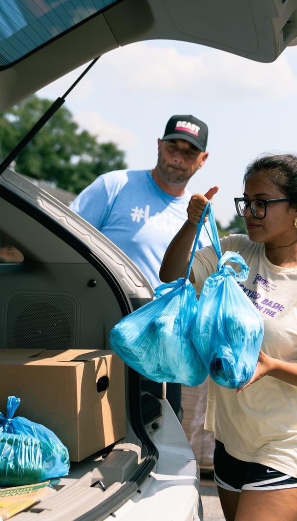 A volunteer handing over bags of groceries