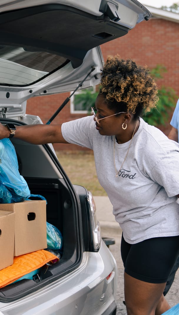 Volunteers filling a car with groceries