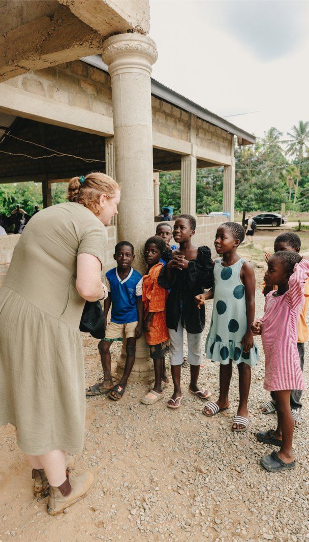 A woman and children outside at a Beast Philanthropy community visit in Ghana