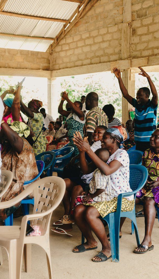 Families raising their hands during the community meeting