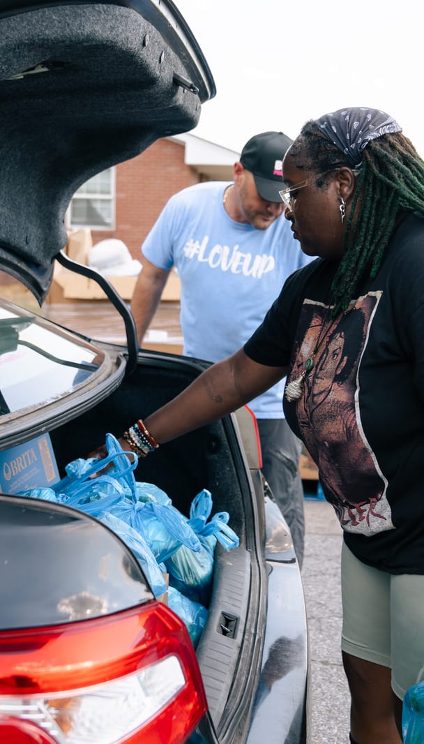A volunteer at the back of a loaded car