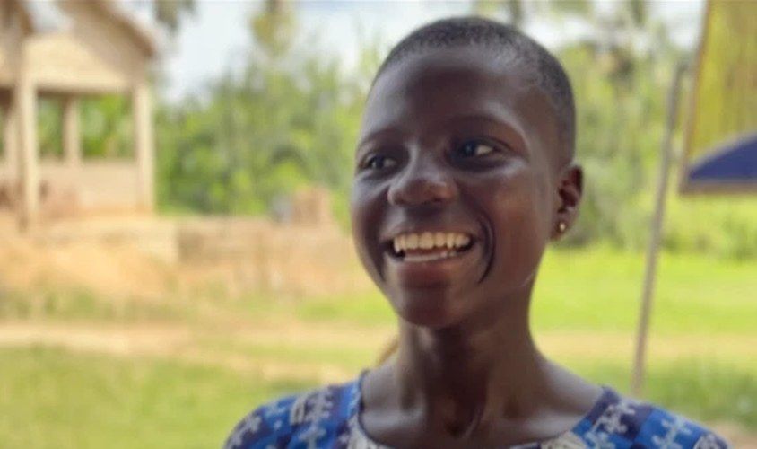Goku smiling outside her school in Ghana