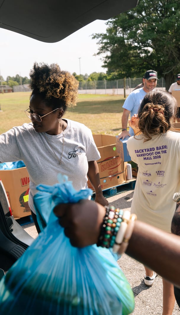 Groceries handed out from an open tailgate