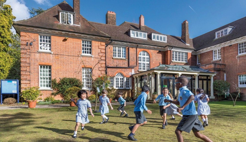 Young pupils at Mill Hill Pre-Prep engaged in an outdoor learning activity in front of the School. 