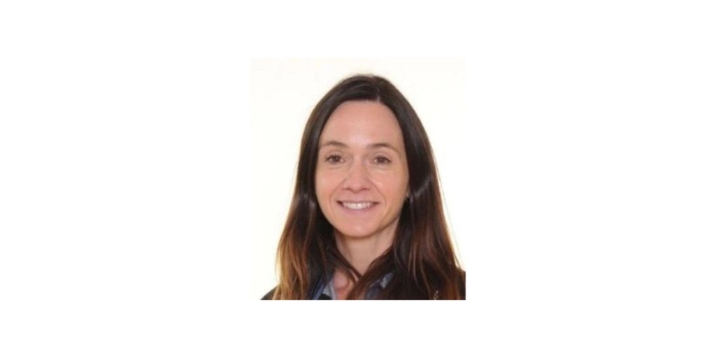 Portrait of the Assistant Head Pastoral and SENCO at Mill Hill School, smiling in a professional headshot with a light background, wearing a dark top.