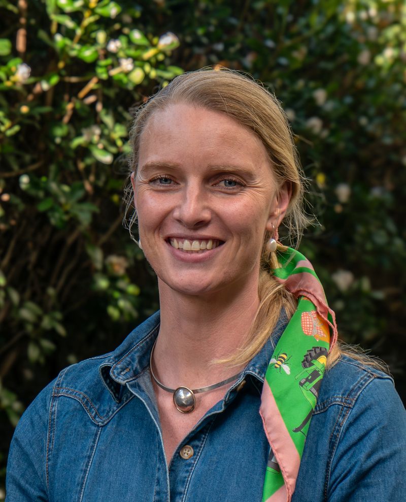Ellie smiling with a demin shirt and colourful hair dressing
