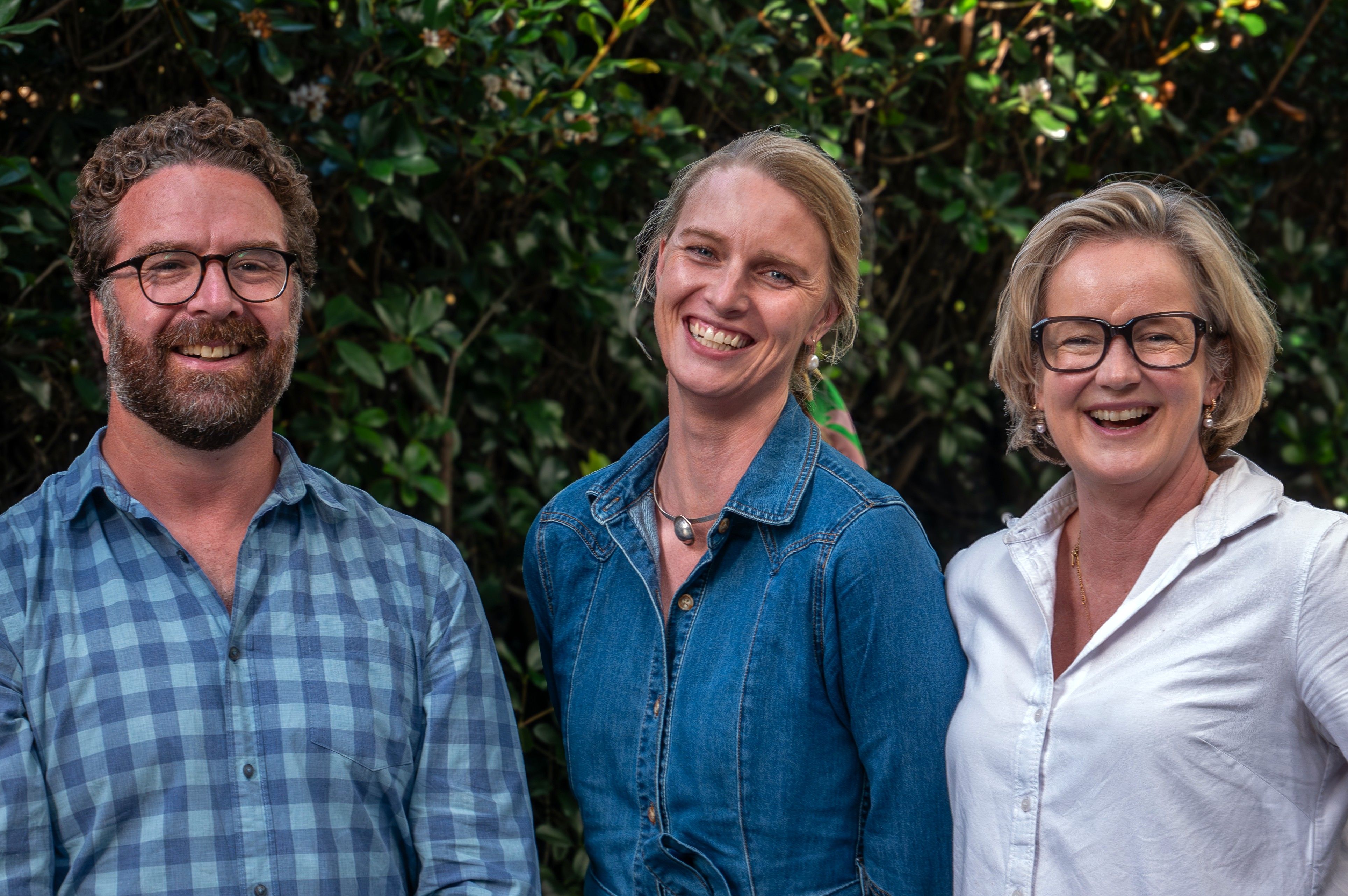 Three members of the LetsCo team smiling together