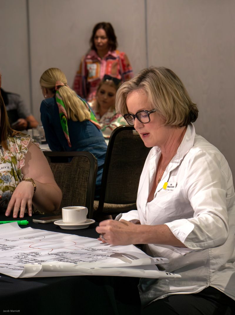 Jac leading a workshop writing on paper