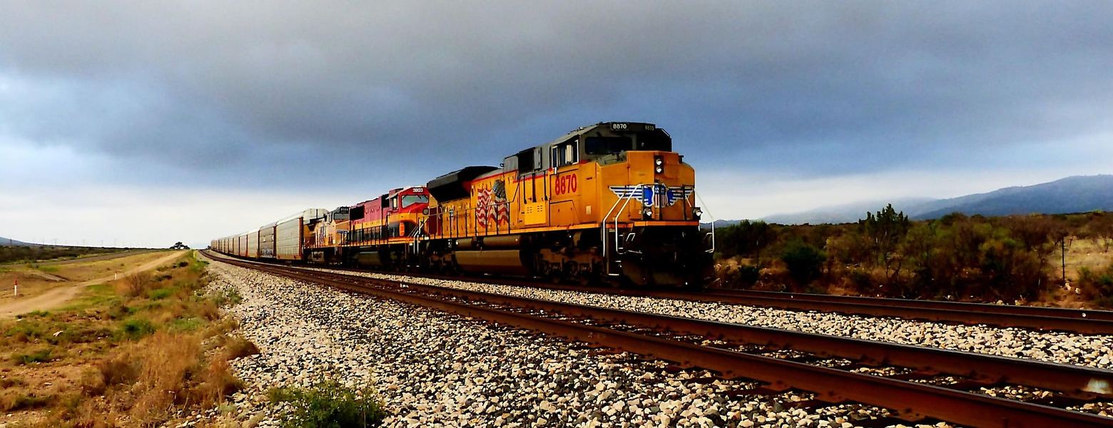A freight locomotive hauling a train along a rural track