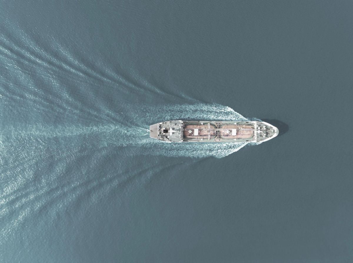 Aerial view of a cargo vessel under way, wake trailing behind