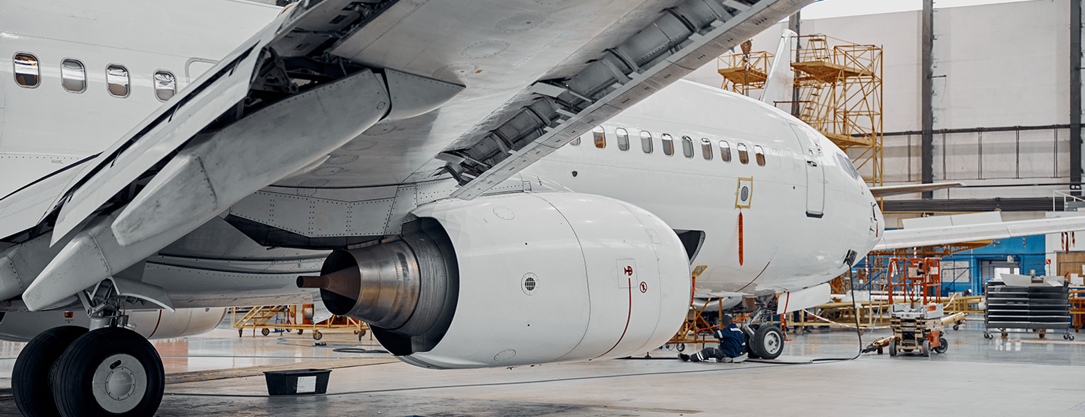 An airliner parked in a maintenance hangar