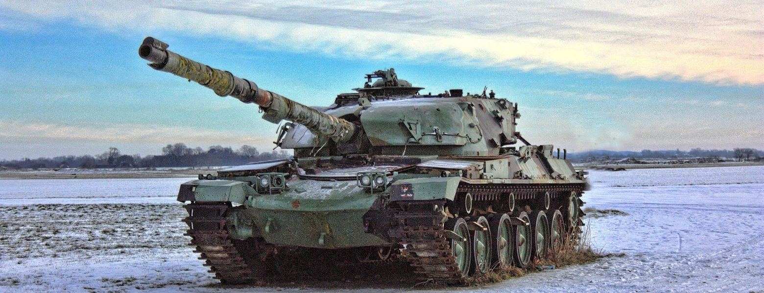 A main battle tank moving across a snow-covered field