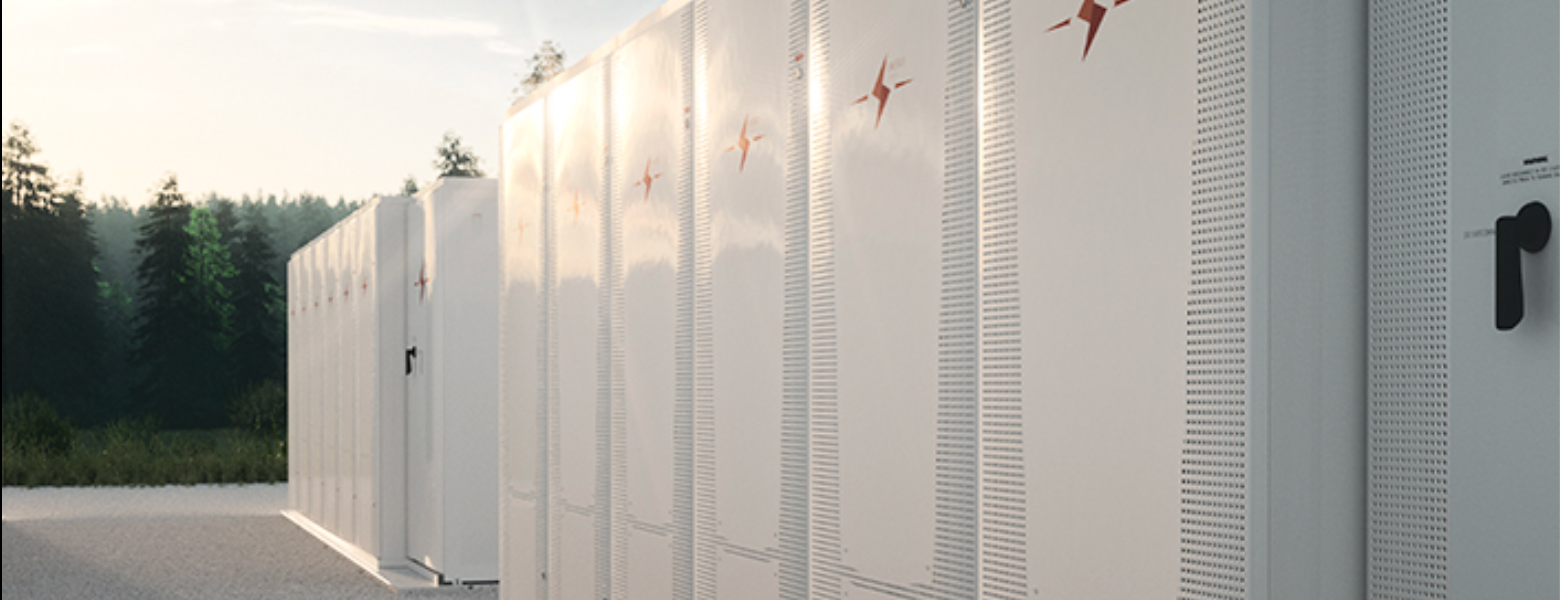 A row of white battery storage cabinets beside a road