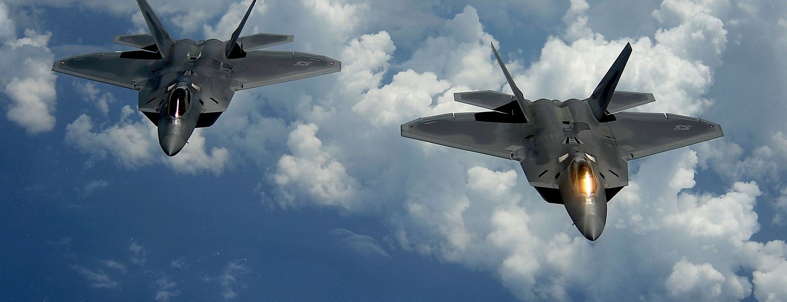 Two fighter jets flying above the clouds