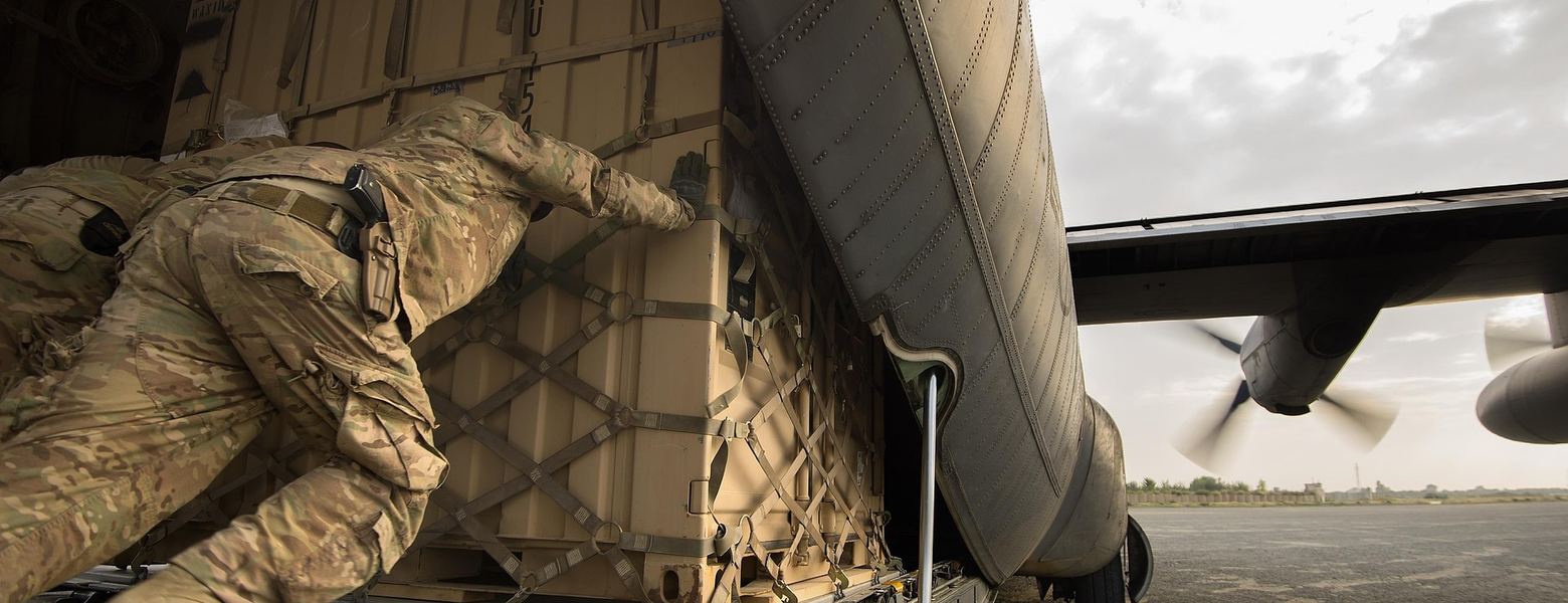 A soldier securing cargo in the hold of a military transport aircraft
